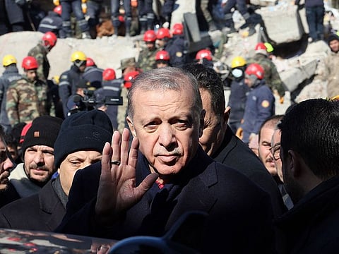 Turkish President Recep Tayyip Erdogan tours the site of destroyed buildings during his visit to the city of Kahramanmaras in southeast Turkey.