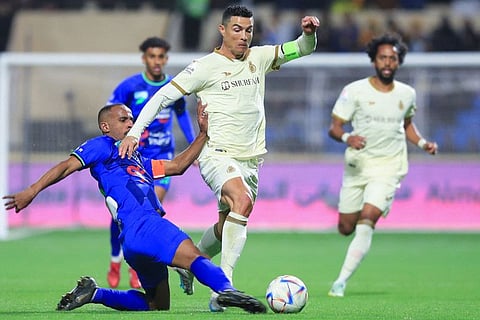 Al Nassr's Portuguese forward Cristiano Ronaldo (right) dribbles past Al Fateh's Saudi midfielder Mohammed al-Fuhaid during the Saudi Pro League match at the Prince Abdullah bin Jalawi Stadium in al-Hasa. Al Nassr face Al Wehda tomorrow night in round 16.