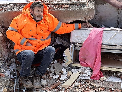 Mesut Hancer holds the hand of his 15-year-old daughter Irmak, who died in the earthquake in Kahramanmaras.