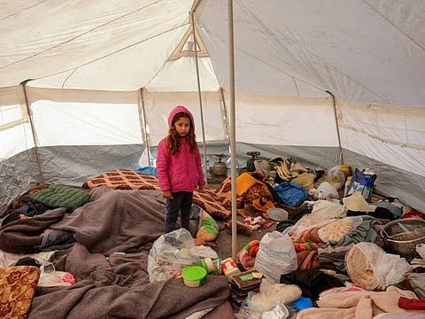 A Syrian girl is pictured in a tent at a make-shift shelter for people who were left homeless, near Jindayris on February 8, 2023.