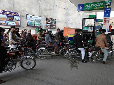 People wait for their turn to get fuel at a petrol station in Peshawar, on January 30, 2023.