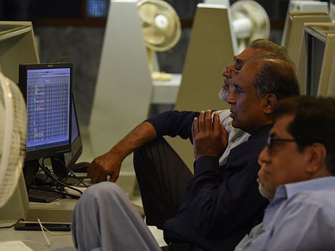 Stockbrokers look at the latest share prices at the Pakistan Stock Exchange (PSE) in Karachi on February 9, 2023.