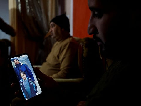 A relative of a Palestinian man, Abdul Karim Abu Jalhoum, who died with his family in the earthquake in Turkey, views his picture on a phone, at the family house in Beit Lahiya in northern Gaza Strip February 8, 2023.
