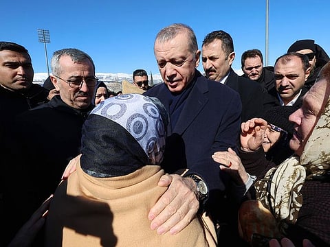 Turkey's President Recep Tayyip Erdogan and a survivor speak in Kahramanmaras, southern Turkey