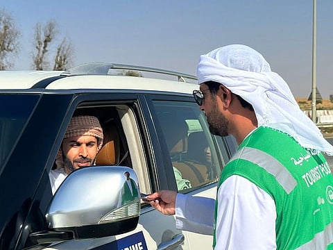 A Dubai Tourist Police official shares a safety brochure with a driver of a tour operator during the campaign