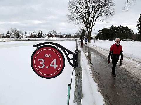Pedestrians walk along the the Rideau Canal in Ottawa, Canada.