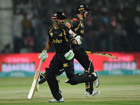Peshawar Zalmi's captain Babar Azam (left) and teammate Tom Kohler-Cadmore run between the wickets during the Pakistan Super League (PSL) Twenty20 match against Karachi Kings at the National Stadium in Karachi.