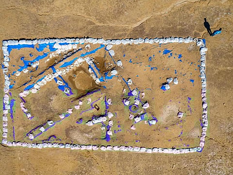 This aerial picture shows Iraqi archaeologist Baqer Azab Wali standing by the newly-excavated trench at the site of the ancient city-state of Lagash, in Iraq's Al Shatra district of the southern Dhi Qar province on February 11, 2023.