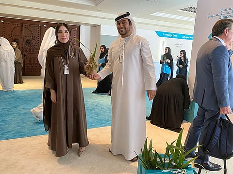 Laila Al Balooshi receives a 'Sustainability Tree' sapling from a member of Sheikh Saif’s office at WGS in Dubai on Wednesday