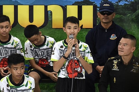 In this file photo taken on July 18, 2018 Duangpetch Promthep (C), one of the 12 boys rescued from deep inside a Thai cave after being trapped for more than a fortnight, speaks during a press conference in Chiang Rai following their discharge from hospital. Duangpetch Promthep has died at a school in Britain, authorities said on February 15, 2023.