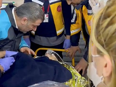 Turkish Health Minister Dr Fahrettin Koca stands with medical staff around a 40-year-old earthquake survivor, after she spent 296 hours under the rubble in Hatay, on February 18, 2023. It is a screengrab obtained from a social media video.