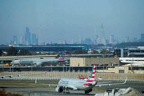 American Airlines planes taxi on the tarmac as the skyline of New York City is seen in the background from the JFK International Airport in New York.