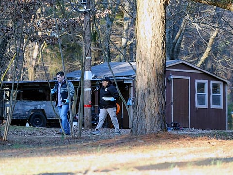 Law enforcement personnel investigate the scene of multiple shootings on Arkabutla Dam Road in Arkabutla on Friday.