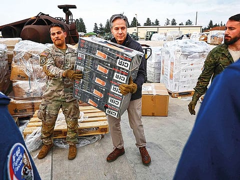 US Secretary of State Antony Blinken (C) helps US military personnel to carry aid, at Incirlik Air Base near Adana, on February 19, 2023, during an official visit after a 7,8-magnitude earthquake struck Turkey's south-east..