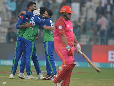 Multan Sultans' celebrate after the dismissal of Islamabad United's Azam Khan (right) during the Pakistan Super League (PSL) Twenty20 cricket match at the Multan Cricket Stadium in Multan.