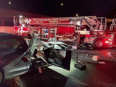 In this photo released by Contra Costa County Fire Protection District, firefighters work the scene of a fatal accident involving a Tesla and Contra Costa County fire truck early Saturday morning, Feb. 18, 2023, in Contra Costa, Calif