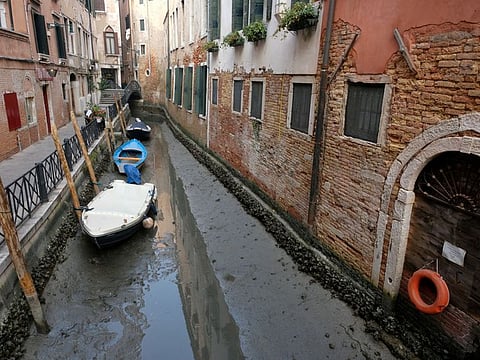Boats are pictured in a canal during a severe low tide in the lagoon city of Venice, Italy, February 17, 2023.