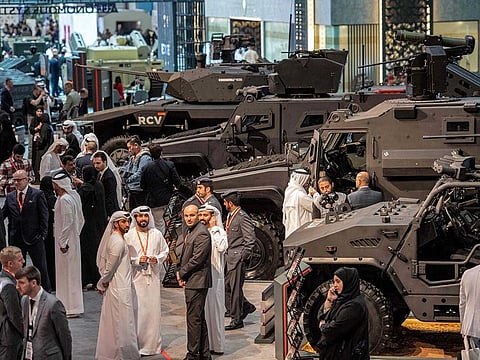 Visitors stand near armoured military vehicles at the EDGE pavilion at the IDEX exhibition.
