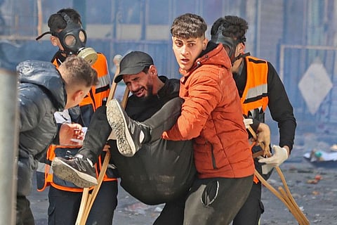 Palestinians carry away a wounded man during an Israeli raid in the West Bank city of Nablus, on February 22, 2023.