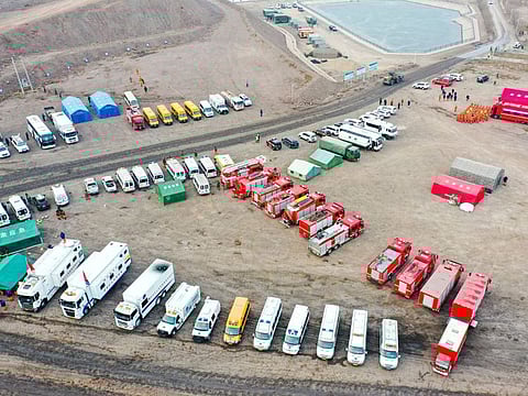 In this aerial photo released by China's Xinhua News Agency, rescue vehicles are parked near the site of a collapsed open pit coal mine in Alxa League in northern China's Inner Mongolia Autonomous Region, Thursday, Feb. 23, 2023.
