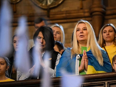 Women prays during the ecumenical prayer service at Ukrainian Catholic Cathedral, in London, on February 24, 2023, mark one year anniversary of war.