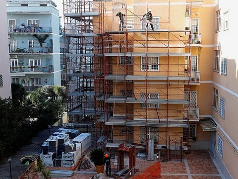 Builders work at the construction site of an energy-saving building, making apartments more energy-efficient under the government's 'superbonus' incentives, in Rome Italy.