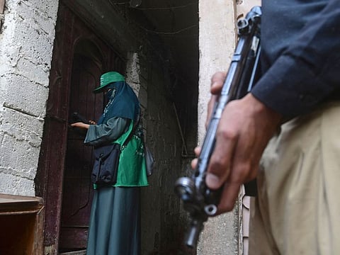An official (left) from the Pakistan Bureau of Statistics uses a digital device to collect information from a resident during door-to-door the first ever digital national census in Karachi on March 1, 2023.