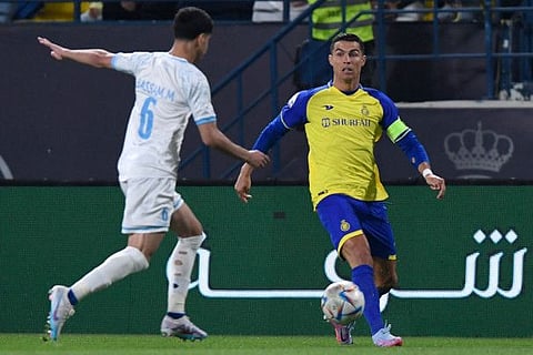 Al Batin's Saudi midfielder Bassam Al Hurayji (left) fights for the ball with Nassr's Portuguese forward Cristiano Ronaldo during the Saudi Pro League match at Mrsool Park Stadium in the Saudi capital Riyadh.