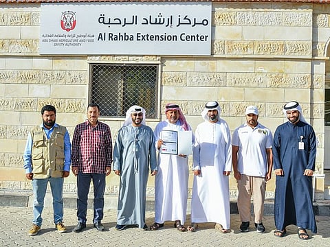 A farm operator (centre) with officials after being awarded the quality certificate