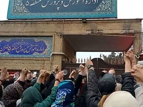 This grab taken from a UGC video made available on the ESN platform on March 4, 2023, shows families gathering and chanting slogans outside an education ministry building in Tehran, following poisoning attacks on students.
