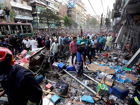 Onlookers gather outside the site of an explosion, in Dhaka, Bangladesh, Tuesday, March 7, 2023.
