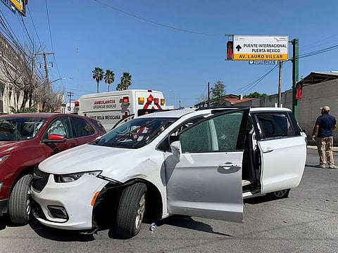 A member of the Mexican security forces stands next to a white minivan with North Carolina plates and several bullet holes, at the crime scene where gunmen kidnapped four U.S. citizens who crossed into Mexico from Texas, Friday, March 3, 2023.