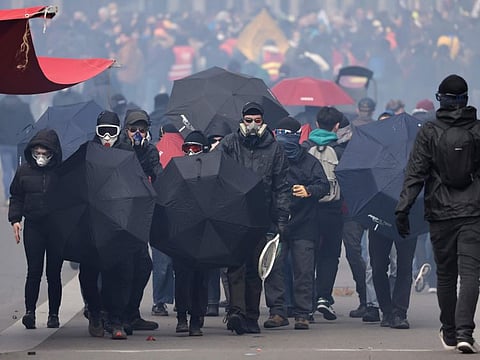 Youths advance with umbrellas during a demonstration Tuesday, March 7, 2023 in Nantes, western France.