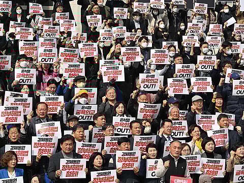 South Korean lawmakers and protesters hold placards during an anti-government rally denouncing South Korea's plans to compensate victims of Japan's forced wartime labour, at the National Assembly in Seoul on March 7, 2023.