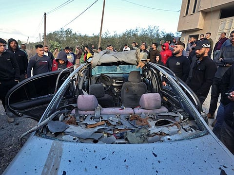 Men and children surround a damaged vehicle after three Palestinians were shot dead by Israeli border police in Jaba in the occupied West Bank on March 9, 2023.