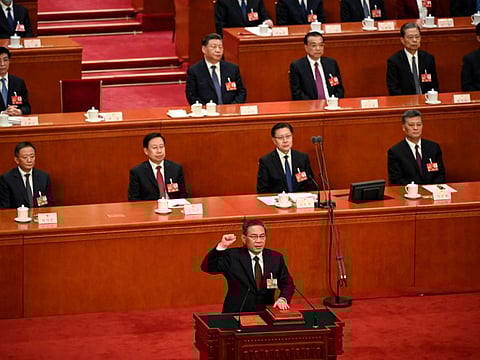 TOPSHOT - China's newly-elected Premier Li Qiang takes an oath after being elected during the fourth plenary session of the National People's Congress (NPC) at the Great Hall of the People in Beijing on March 11, 2023. (Photo by GREG BAKER / POOL / AFP)