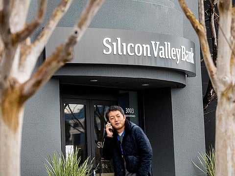 A pedestrian speaks on a mobile telephone as he walks past Silicon Valley Bank’s headquarters in Santa Clara, California on March 10, 2023.