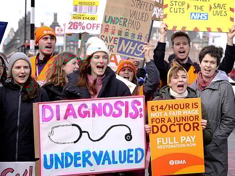 Junior doctors hold placards as they stand at a picket line outside St Thomas' Hospital in Westminster in London, Monday, March 13, 2023.