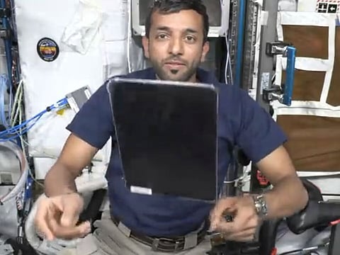 Still from video showing Al Neyadi flipping an iPad on ISS