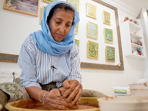 Awatif Al Keneibit moulds clay making the base of sculptures in her studio in Riyadh, Saudi Arabia.