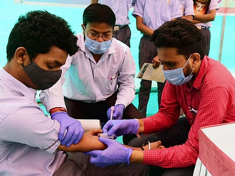 A health worker collects blood sample from a school student during a checkup as a precaution against the H3N2 virus in Ahmedabad, Gujarat, in India on March 11, 2023. There has been spike in flu infections across the country.