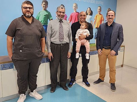 Mariam with her father and a team of doctors after successful treated her life-threatening chest infection