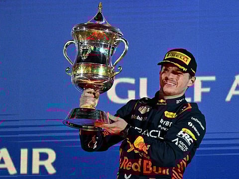 Red Bull Racing's Dutch driver Max Verstappen celebrates with the winner's trophy on the podium after the Bahrain Grand Prix.