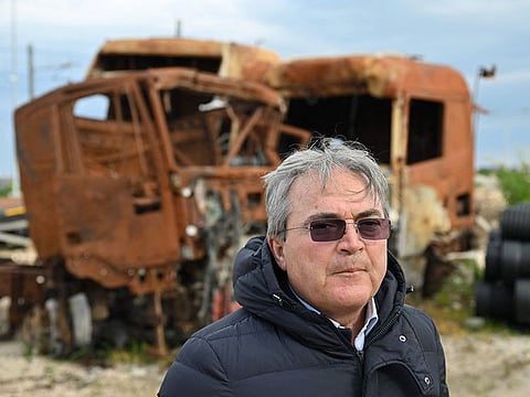 Italian farmer Lazzaro D'Auria poses in front of burned vehicles on March 6, 2023 in San Severo, in the province of Foggia