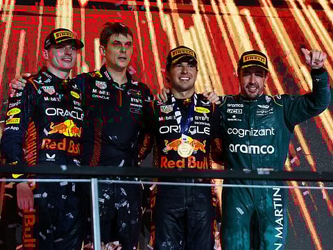 Red Bull's Sergio Perez celebrates on the podium after winning the Saudi Arabian Grand Prix alongside second placed Red Bull's Max Verstappen and third placed Aston Martin's Fernando Alonso before he was handed a 10 second time penalty that drops him to fourth place in the final results.