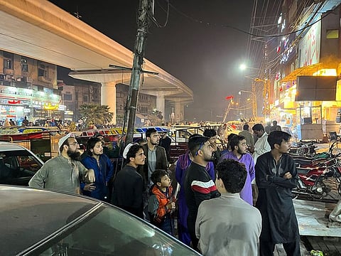 People come out of a restaurant after a tremor was felt in Lahore, Pakistan.