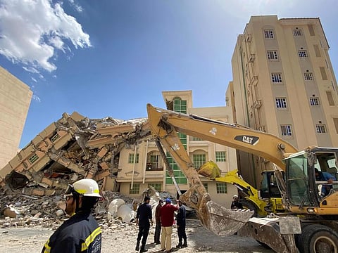 Qatari security forces and rescuers gather in front of a building that collapsed in Doha on Wednesday.