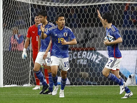 Japan's Takuma Nishimura celebrates with teammates after scoring their first goal.