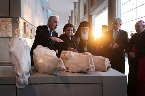 Acropolis Museum Director Nikolaos Stampolidis presents one of three Parthenon fragments, returned from the Vatican, to officials attending the ceremony at the Parthenon Gallery of the Acropolis Museum, in Athens.