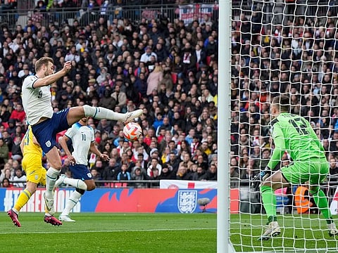 Englands' Harry Kane, left, makes an attempt to score past Ukraine's goalkeeper Anatoliy Trubin during the Euro 2024 group C qualifying soccer match between England and Ukraine at Wembley Stadium in London, Sunday, March 26, 2023.